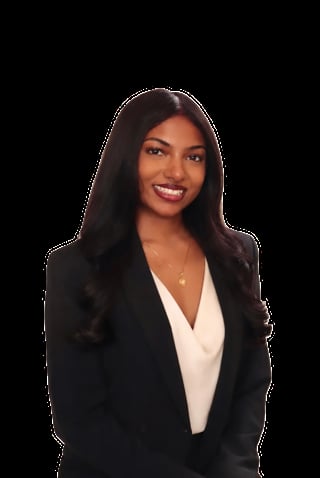 Professional headshot of a woman with long dark hair wearing a black blazer over a white blouse, smiling against a black background